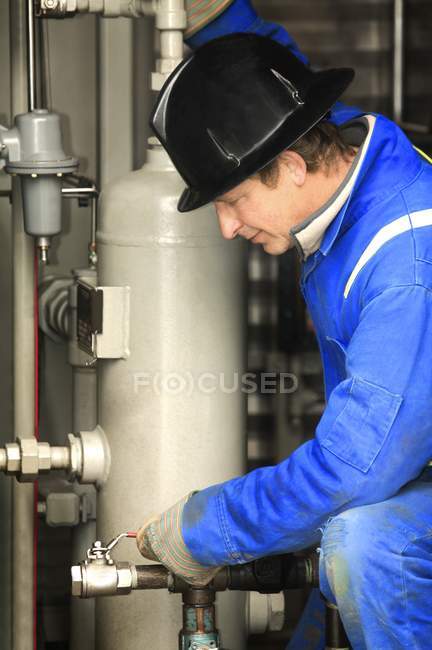 Uomo che lavora alla raffineria di petrolio — Foto stock