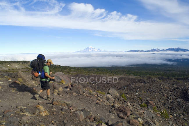 Mochilero caminando pasado Monte Rainier - foto de stock