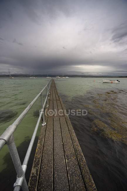 Pier, der sich ins Wasser erstreckt — Stockfoto
