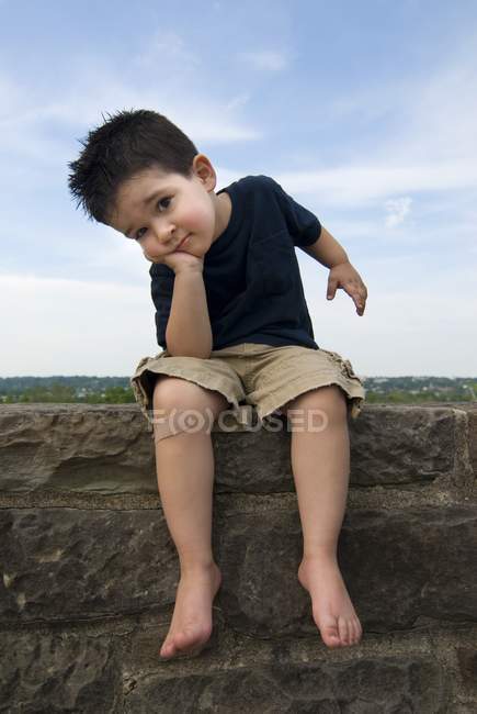 Niedliche kaukasische Junge mit Verband sitzt und schaut in die Kamera — Stockfoto