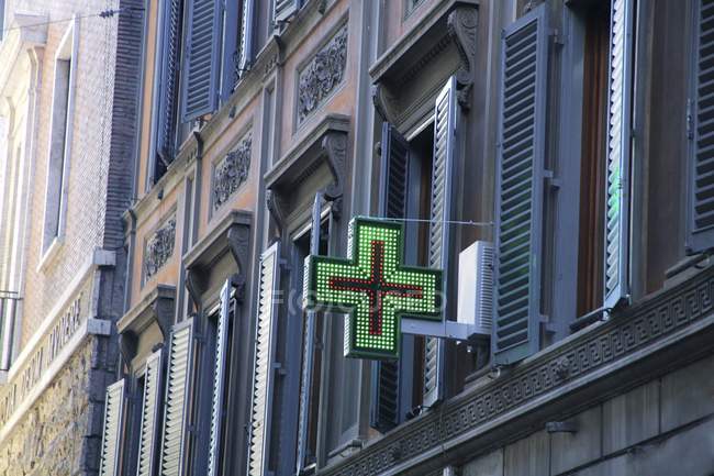 Cruz médica roja y verde en el edificio - foto de stock