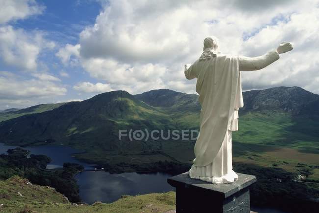Escultura de Jesús contra colinas - foto de stock