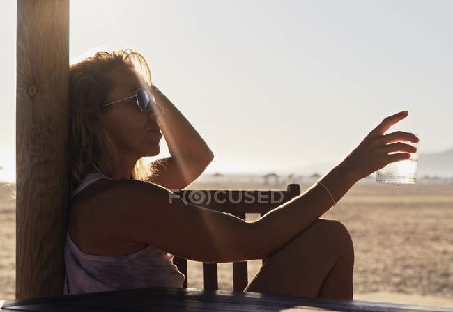 Femme assise sur une plage pendant la journée — Photo de stock