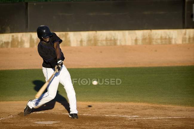 Jogador profissional de beisebol balançando seu morcego — Fotografia de Stock