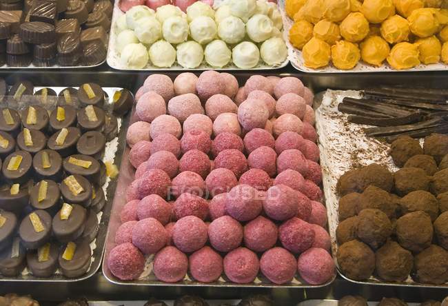 Chocolates y dulces hechos a mano en bandejas en el mercado - foto de stock