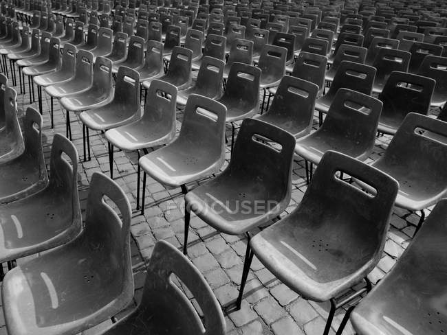 Black and white image of Chairs in a row — Stock Photo