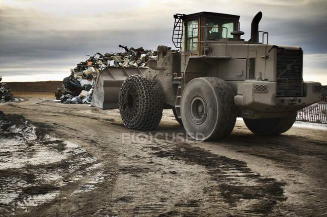 Днем копатель в мусорном дворе — стоковое фото