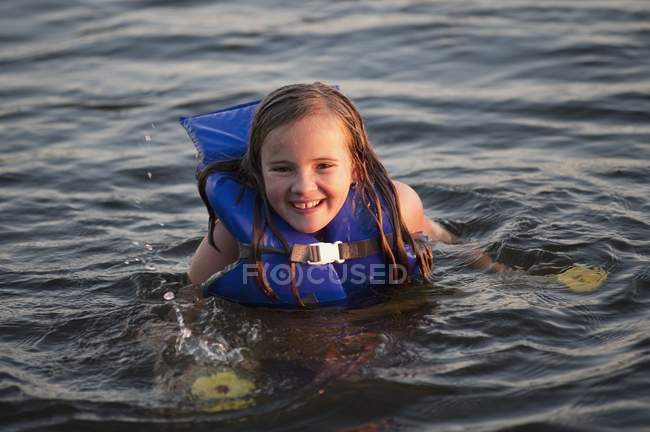 Chica en el agua con dispositivo de flotación personal - foto de stock