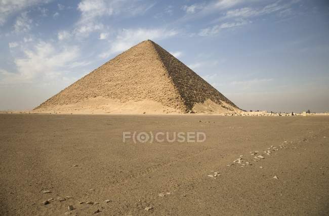 Red Pyramid on sand field — Stock Photo