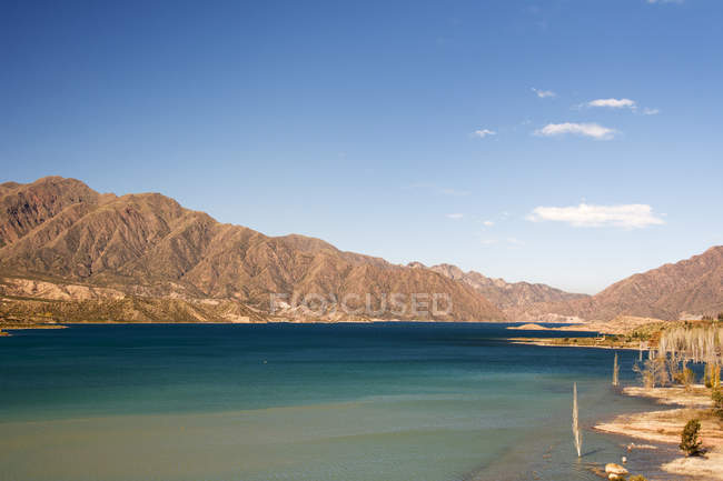 Un lago circondato da montagne colorate del deserto; Potrerillos, Mendoza, Argentina — Foto stock