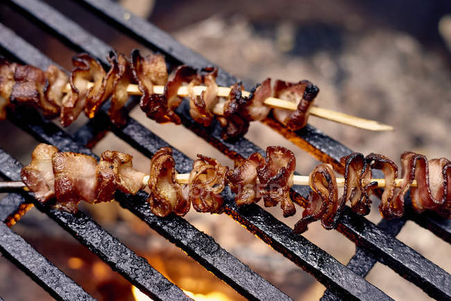 Bacon Skewers Cooking Over A Flame On A Grill; Ontario, Canada — Stock Photo