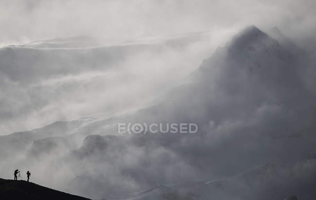 Фотографы силуэт против снежной горы Ладен; Исландия — стоковое фото