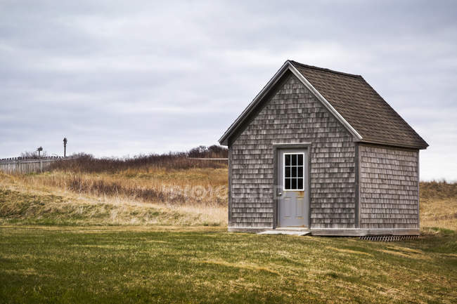 Старий будинок над полем з зеленою травою вдень — стокове фото