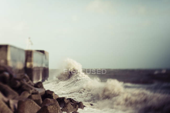 Acqua ondulata contro la riva rocciosa con pietre durante il giorno — Foto stock