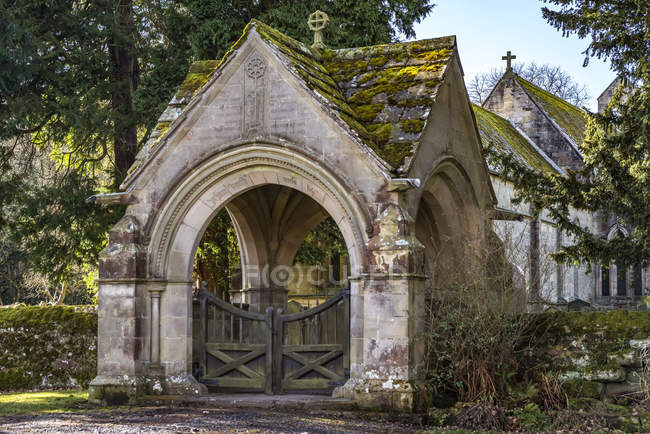 Puerta de entrada a la iglesia parroquial medieval de St. Mungos Simonburn en Northumberland rural, con rastros de una iglesia anglicana del siglo IX, pero el edificio actual es principalmente del siglo XIII; Simonburn, Northumberland, Inglaterra - foto de stock