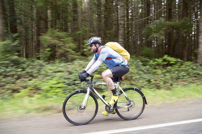 Vista lateral do Cyclist Riding Through Pacific Rim National Park; Vancouver, British Columbia, Canadá — Fotografia de Stock