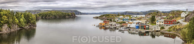Vista panorâmica da água do mar, montanhas e pequena aldeia na costa e árvores em outra costa — Fotografia de Stock