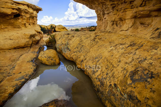 Pool of Water Trapped By Rocks Reflecting Sky And Clouds In El Malpais National Monument Near Grants, Novo México No início do outono; Novo México, Estados Unidos da América — Fotografia de Stock