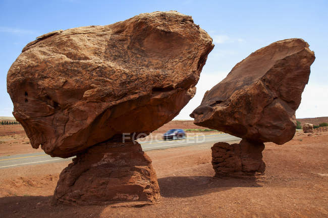 Геологічні утворення відомий як 'балансування скелі' розташований поблизу Лі пором, Az на американських індіанців землі, як видно в середині літа з A автомобіль подорожі на шосе і Синє небо поза її межами; Арізона, Сполучені Штати Америки — стокове фото