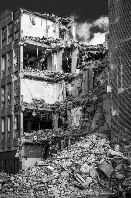 Un edificio en demolición con una pila de escombros en la planta baja y los pisos del edificio expuestos; Newcastle Upon Tyne, Tyne and Wear, Inglaterra - foto de stock
