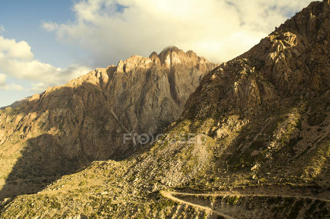 Strada sterrata su un lato della montagna nelle Ande al tramonto; Mendoza, Argentina — Foto stock