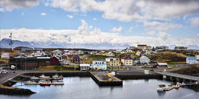 Casas coloridas y pequeñas embarcaciones en un puerto, Península de Snaefellsnes; Islandia - foto de stock