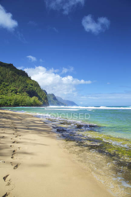 Blick auf den leeren Sandstrand mit ruhigem blauem Meer und Hügeln im Hintergrund — Stockfoto