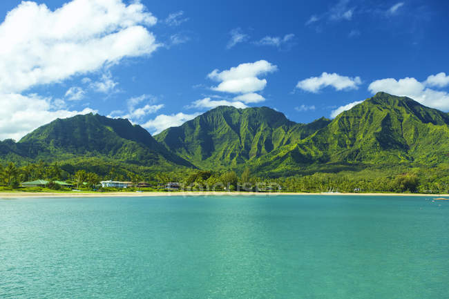 Calmo azul água do mar e colinas na costa sob céu nublado — Fotografia de Stock