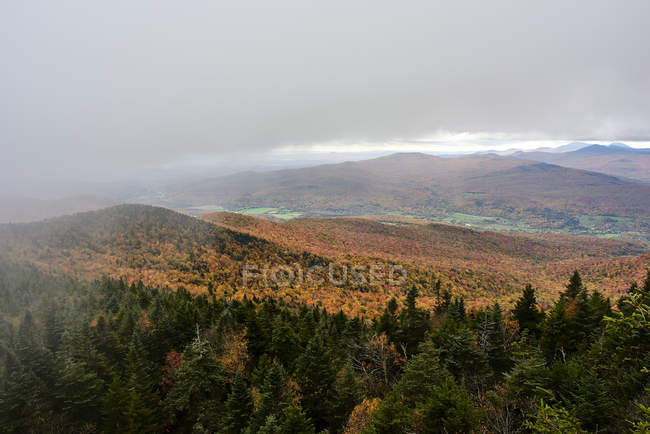 Cascate pluviali dalle nuvole pesanti sopra una foresta colorata di autunno nelle montagne; Dunham, Quebec, Canada — Foto stock