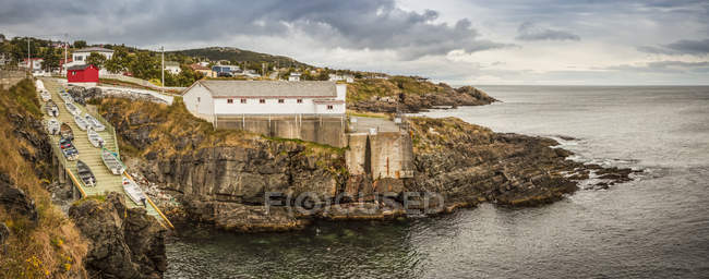 Fishing sheds and cliffs with stratum along the Atlantic coastline; Bonavista, Newfoundland, Canada — Stock Photo
