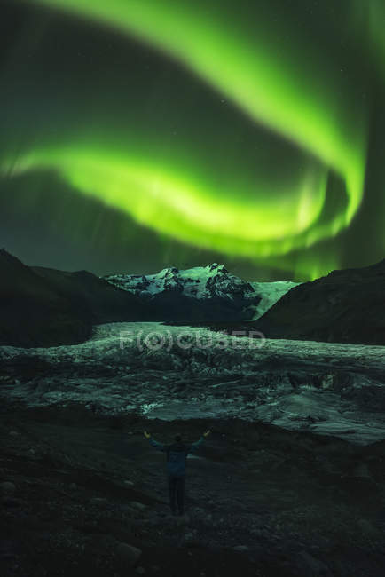 Зеленый северный свет над горами и озерной водой ночью — стоковое фото