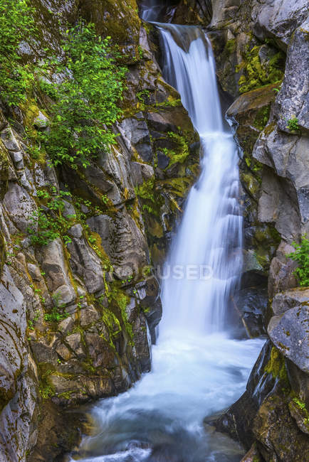 Cascata che scorre sopra una scogliera rocciosa con fogliame lussureggiante; Washington, Stati Uniti d'America — Foto stock