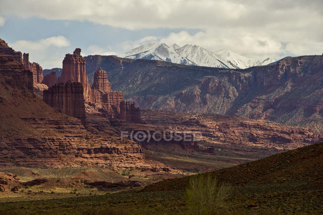 View of rock formations and snowcovered peaks on background during daytime — Stock Photo