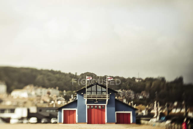 A boat house with three red doors at the waterfront; London, England — Stock Photo