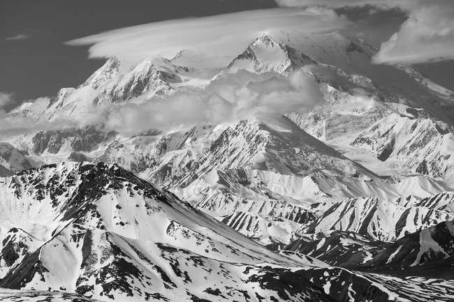 Schwarz-weißes Bild von schneebedeckten Berggipfeln unter bewölktem Himmel — Stockfoto