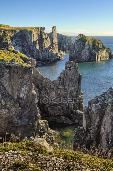 Grandes formações rochosas sobre a água do mar calma durante o dia — Fotografia de Stock