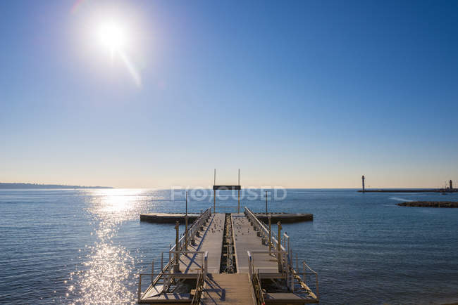 Muelles que conducen al agua azul del mar Mediterráneo a lo largo de la Rivera francesa; Cannes, Costa de Azur, Francia - foto de stock