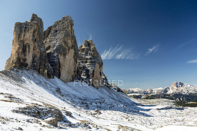 Dramatic mountain spires on top of snow-covered rocky plateau and blue sky; Sesto, Bolzano, Itália — Fotografia de Stock