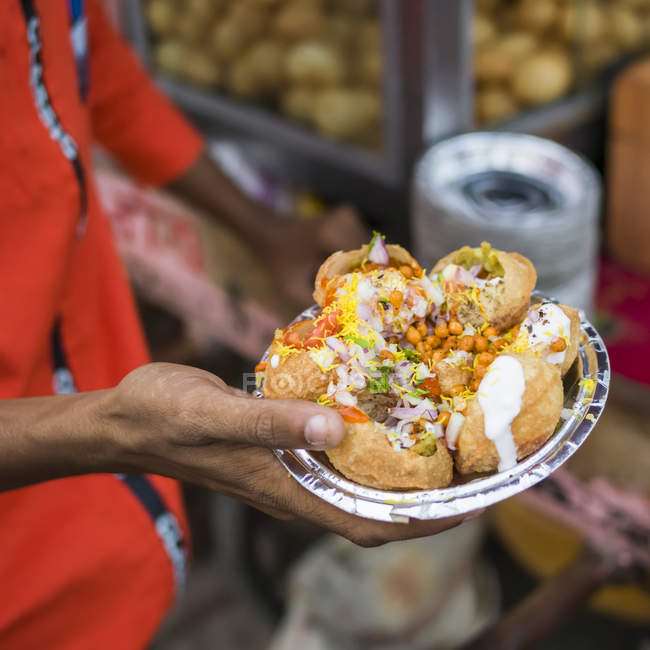 Eine Hand hält einen Folienteller mit einer Portion traditioneller indischer Speisen; jaipur, rajasthan, india — Stockfoto