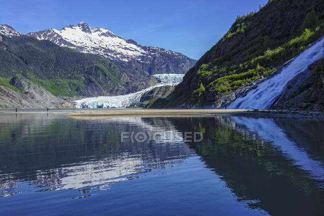 Tourists viewing Mendenhall Glacier and Nugget Falls in Mendenhall Park Recreation Area, near Juneau; Alaska, United States of America — Stock Photo