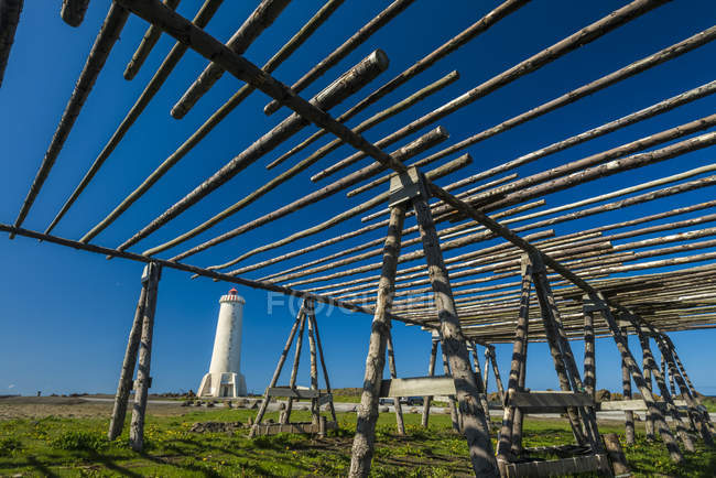 Alte Fischtrocknungsanlagen neben einem Leuchtturm; akranes, Island — Stockfoto