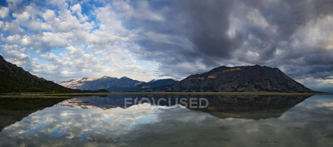 Montagnes dans la chaîne de St. Elias reflétées dans un lac tranquille, parc national et réserve de parc national Kluane ; Destruction Bay, Yukon, Canada — Photo de stock