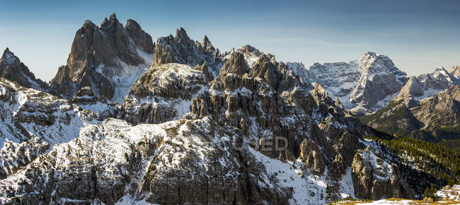 Rugged snow-covered mountain range with blue sky; San Candido, Bolzano, Italy — Stock Photo