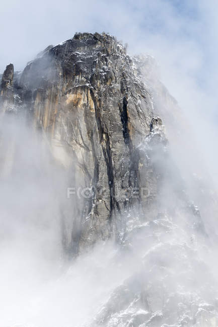 Torre de granito rodeada de nubes, Parque Nacional Yosemite, California, Estados Unidos de América - foto de stock