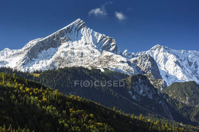 Cordilheira rochosa coberta de neve com céu azul; Garmisch-Partenkirchen, Baviera, Alemanha — Fotografia de Stock