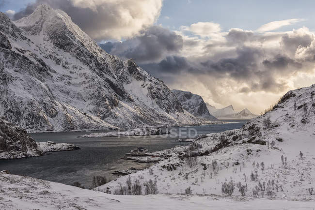 Montañas resistentes cubiertas de nieve a lo largo de la costa de Noruega; Nordland, Noruega - foto de stock