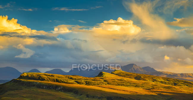 Luz solar que ilumina el paisaje montañoso y las nubes; Isla de Skye, Escocia - foto de stock