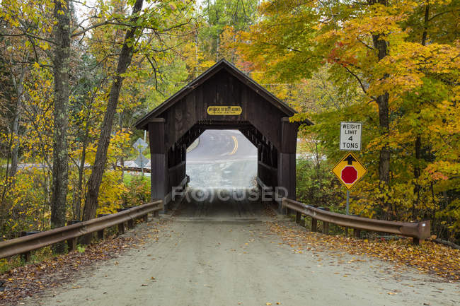 A covered bridge on a back country road in autumn, Green Mountains; Stowe, Vermont, United States of America — Stock Photo