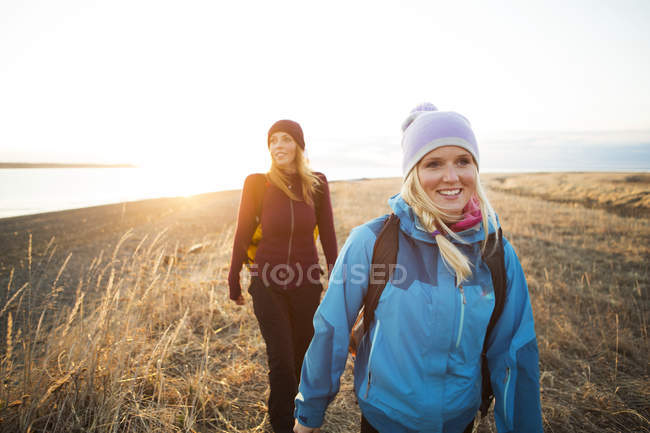 Two young women hiking along the coast at sunrise; Anchorage, Аляска, США — стоковое фото