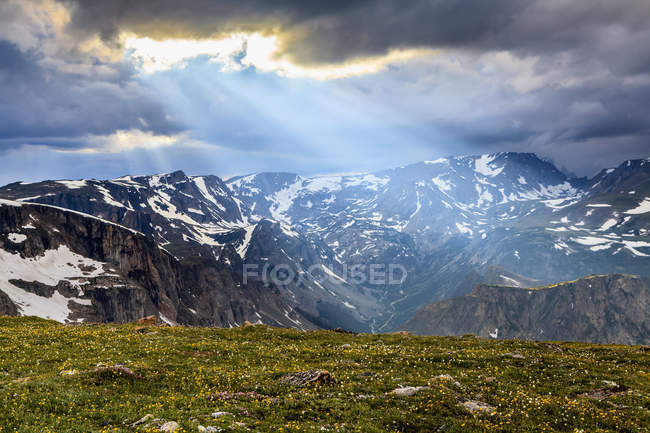 View from the Beartooth Highway of the Beartooth Mountains and the sun rays breaking through the clouds; Cody, Wyoming, United States of America — Stock Photo